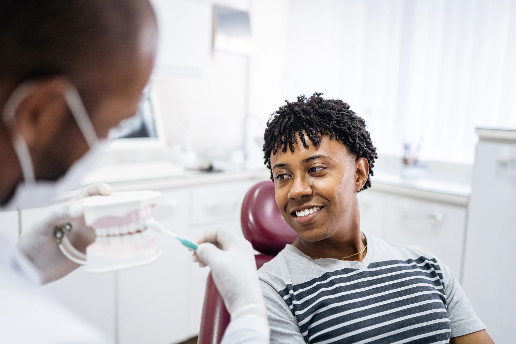 Dentist demonstrating brushing technique to a patient